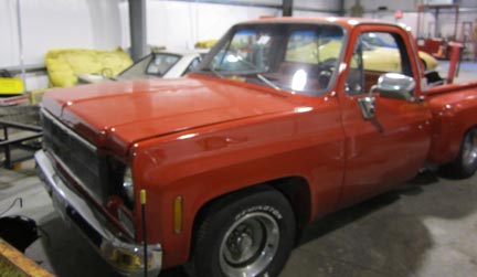 Red flatbed pickup truck restored at C&S Auto, pictured in our wheel alignment facility